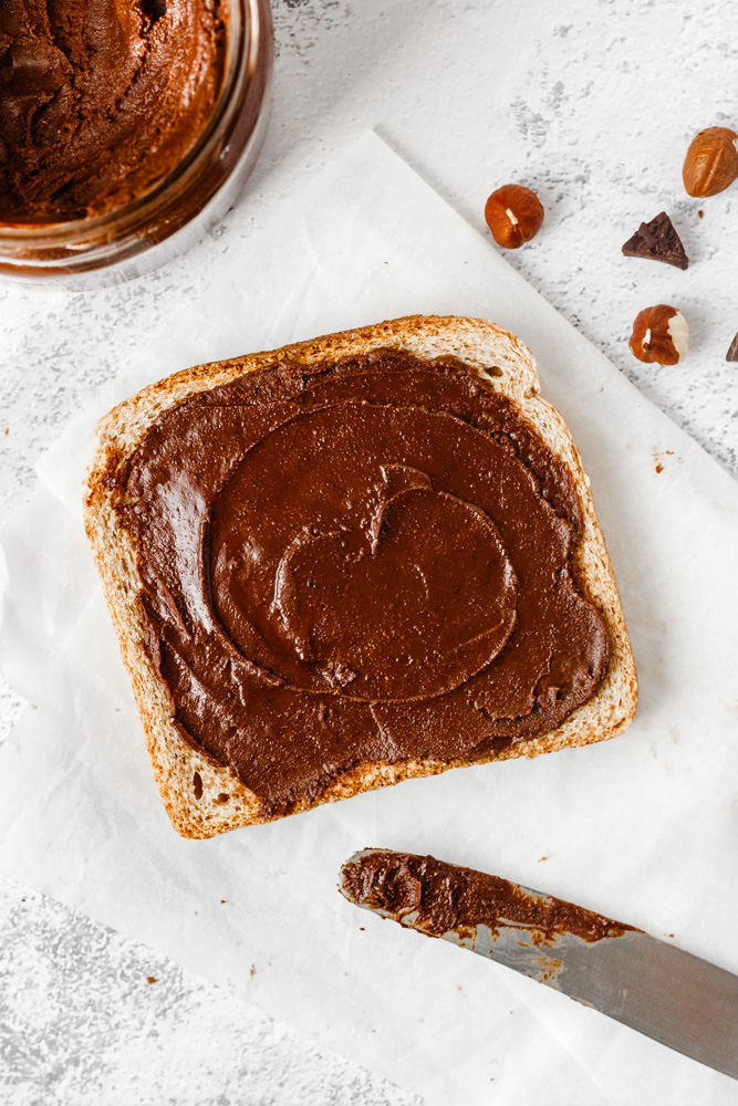Vegan Nutella namazaná na plátku chleba