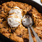 Close Up Of Chocolate Chunk Skillet Cookie Topped With Ice Cream, With Two Spoon