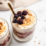 Overnight Oats In Glass Topped With Peanut Butter And Blackberries