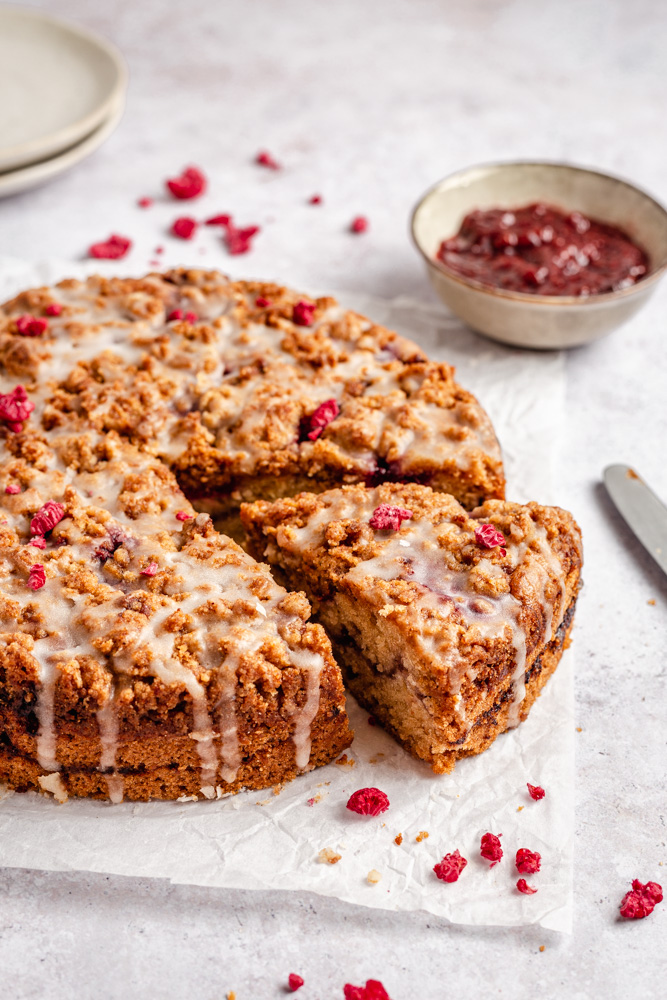 Raspberry cake with streusel topping drizzled with glaze