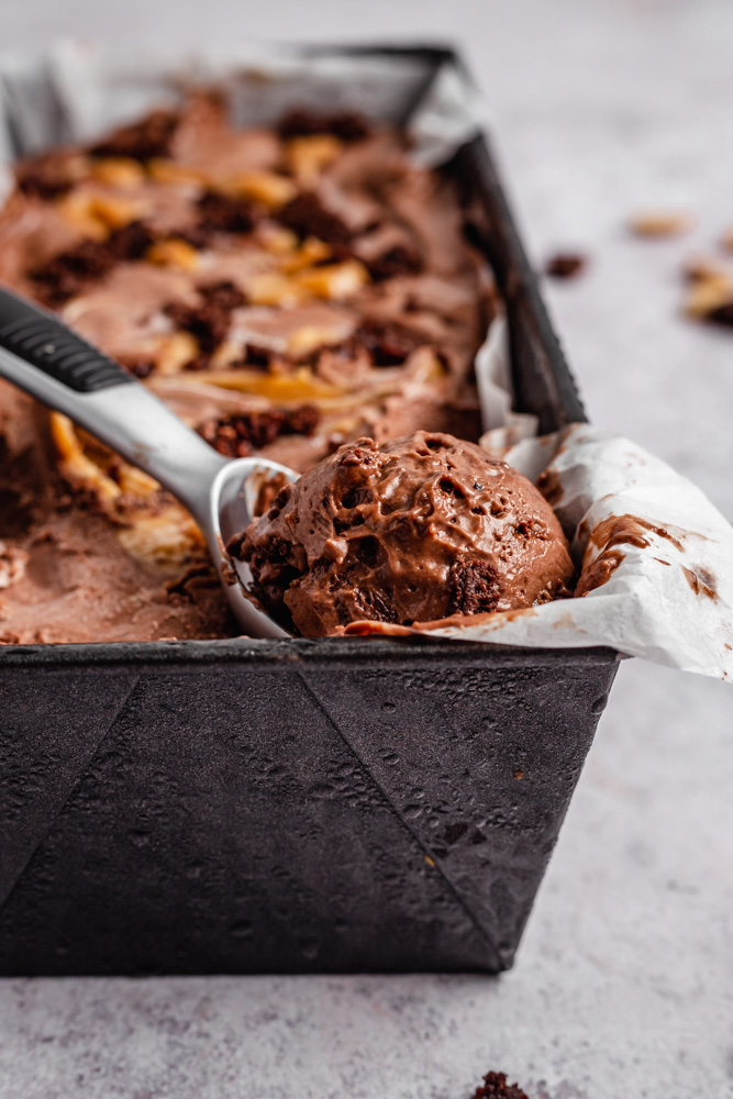 Dairy-free brownie ice cream swirled with peanut butter caramel in a loaf pan
